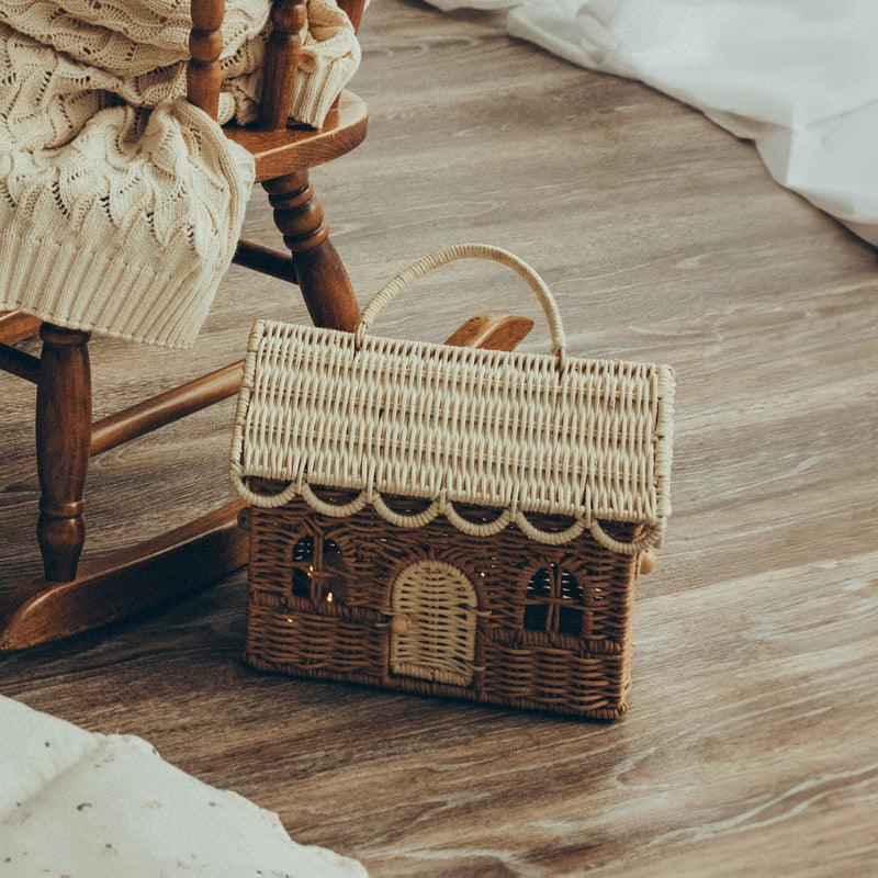 rattan dollhouse sitting on the floor 