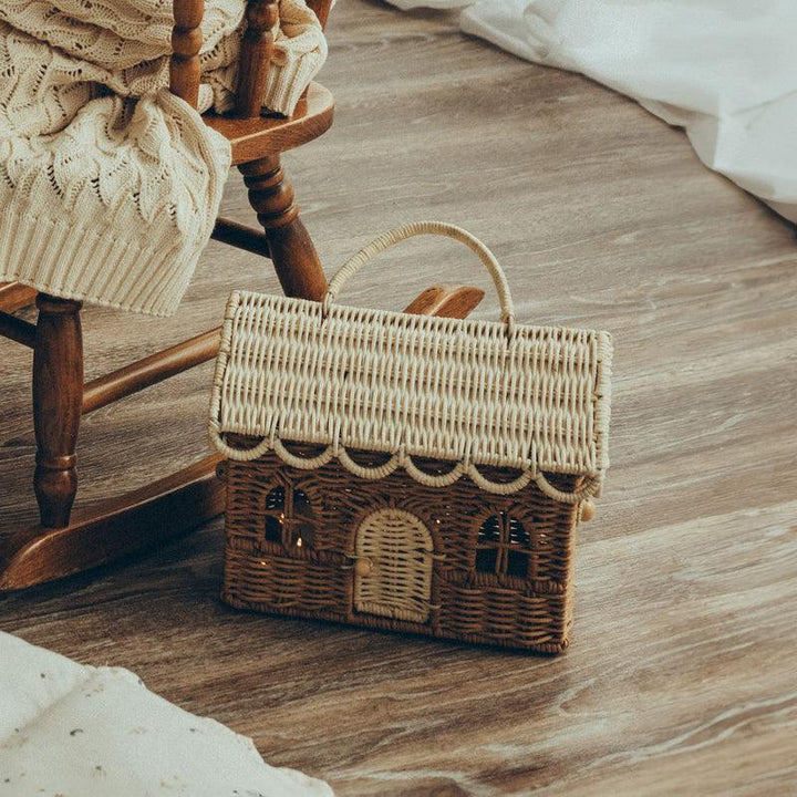 rattan dollhouse sitting on the floor 