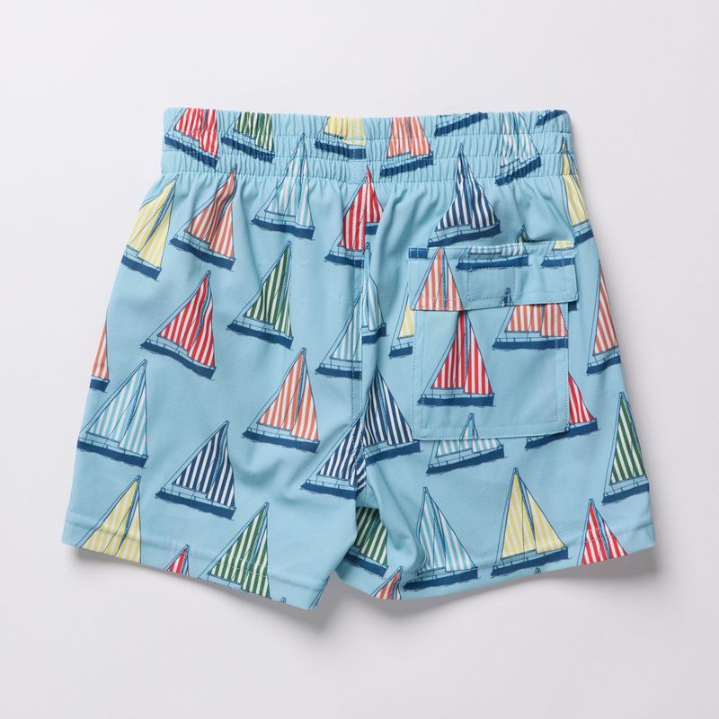 Blue swim shorts with sailboat pattern on a light gray background