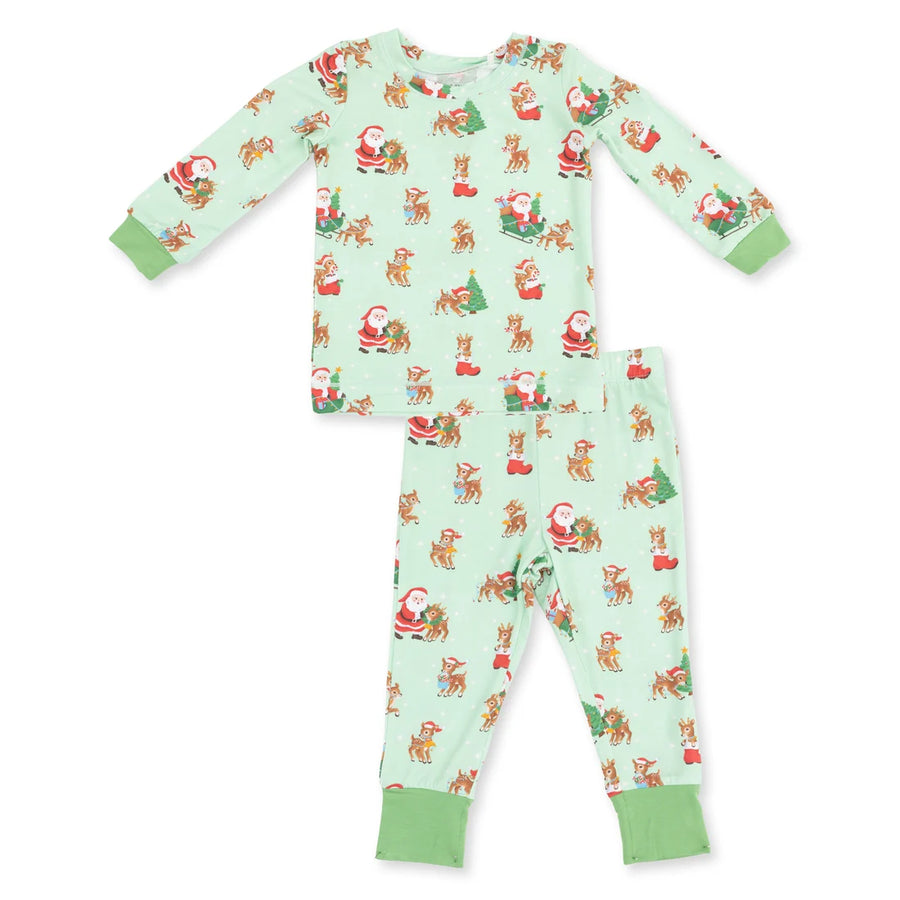 A two-piece children's pajama set featuring a long-sleeve top and matching pants in a light mint green color, printed with a festive holiday pattern of Santa Claus, reindeer, and Christmas trees, finished with solid light green ribbed cuffs and ankles.