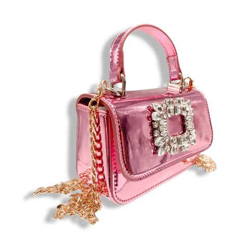 sideview of the metallic Pink handbag with a decorative rhinestone clasp on a white background