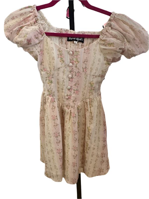 girls dress with faux buttons going down the center and puff sleeves. pastel print with tiny florals in pink and beige. 