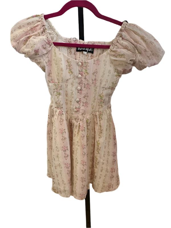 pink and beige floral dress with puff sleeves and faux buttons going down the center, smocking in the back and a-line skirt. 