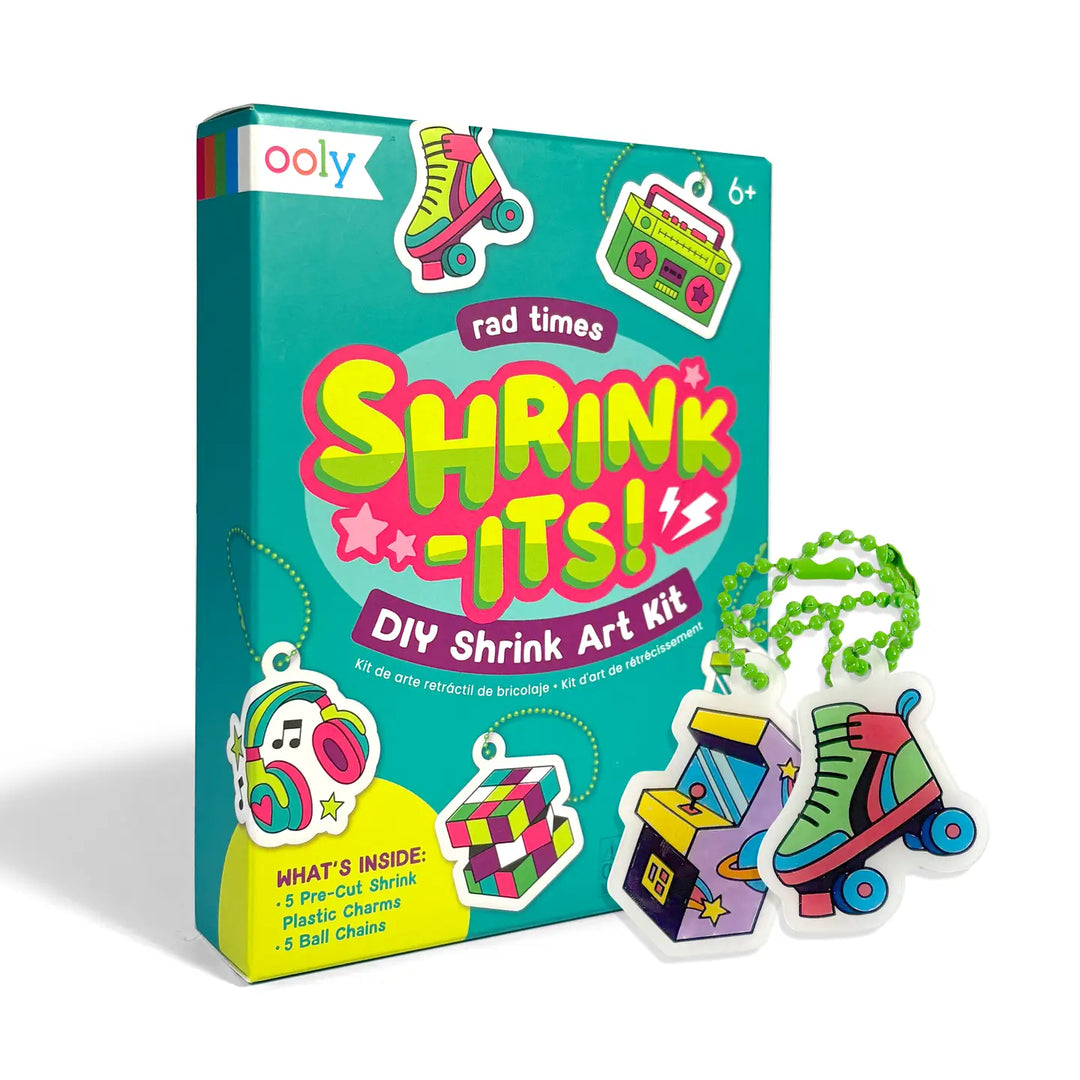 Ooly DIY Shrink Art Kit box shown on a white background with several colorful shrink-wrapped craft pieces placed in front, including roller skates, a boombox, a music player, and a cube.