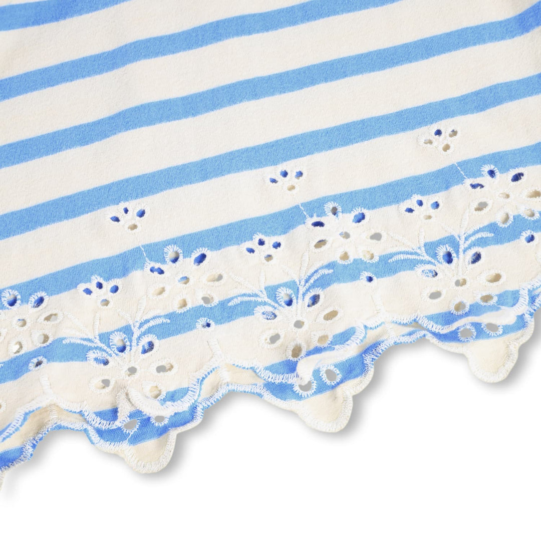 Close-up of a fabric with blue and white stripes and decorative edge on a white background