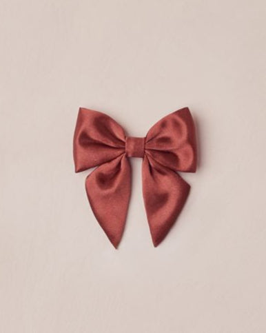 Red satin bow on a beige background