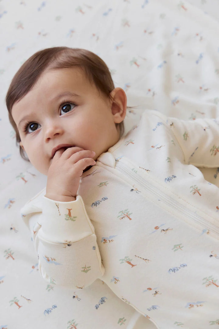 Baby wearing a savannah animal patterned onesie on a white background