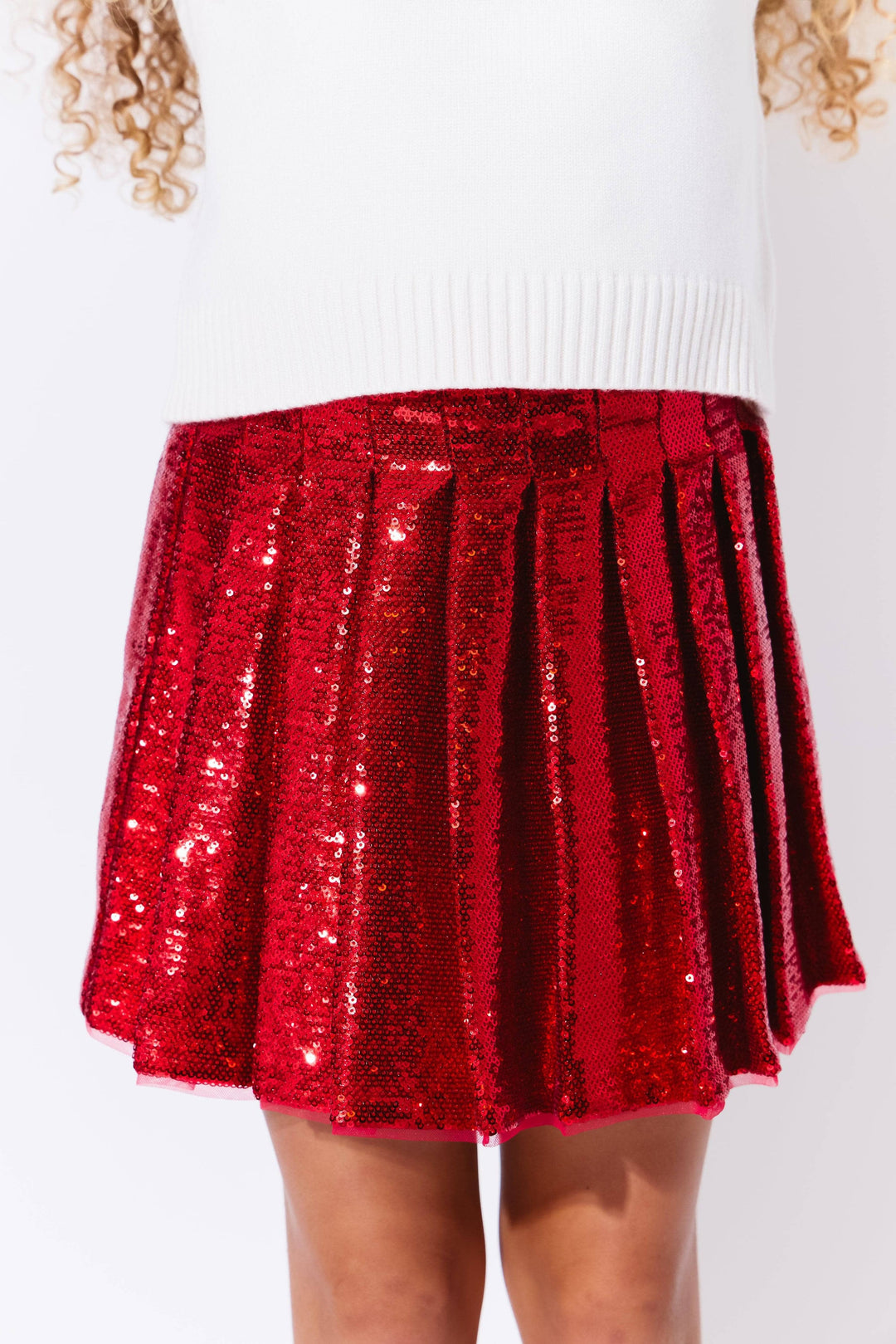 Red sequin skirt worn by a person on a white background
