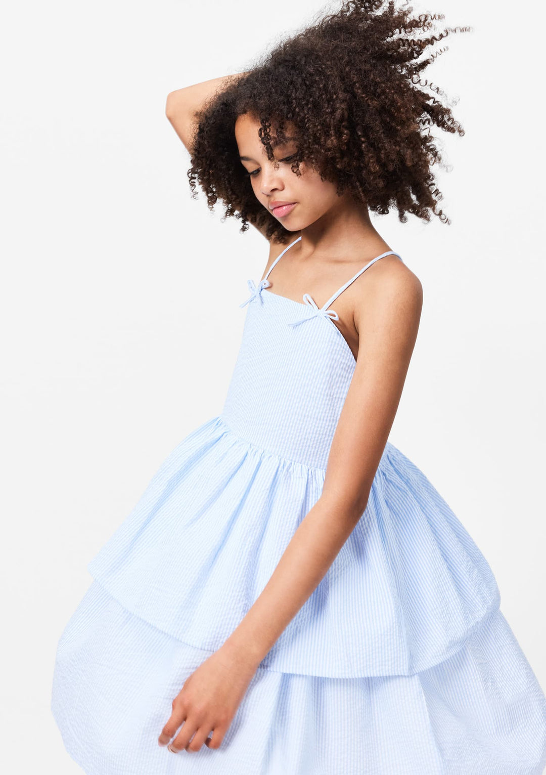 young girl wearing a light blue dress against a white background