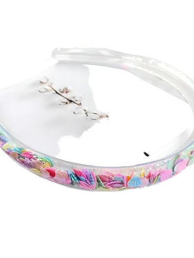 transparent headband filled with sparkly multi colored shells. 