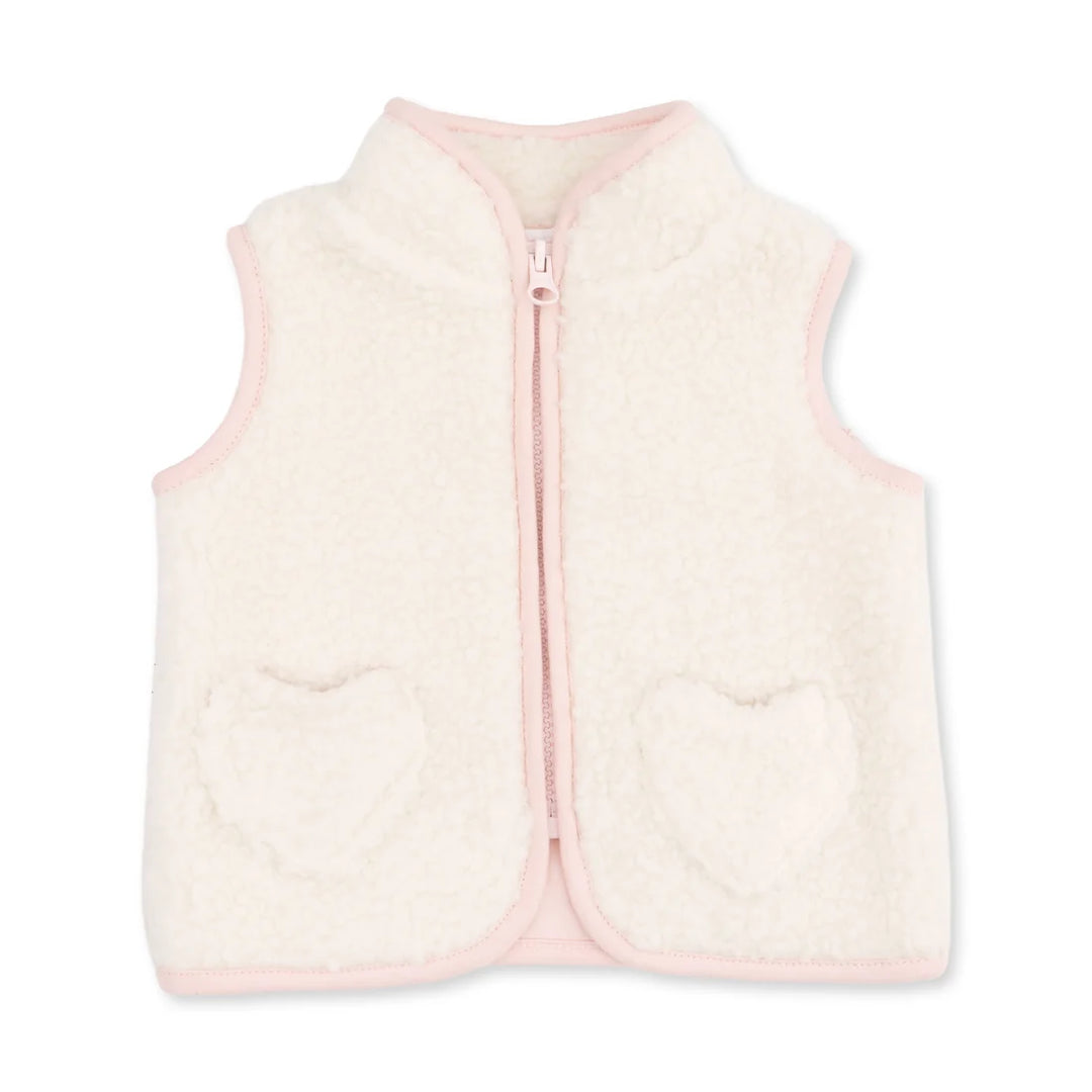 A cream-colored sherpa fleece vest with light pink trim, featuring a front zipper and two heart-shaped pockets on the front.