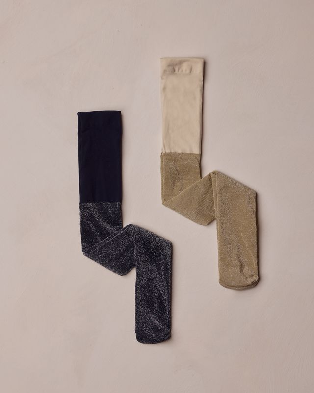 Two pairs of shimmer stockings, one black and one beige, on a beige background.