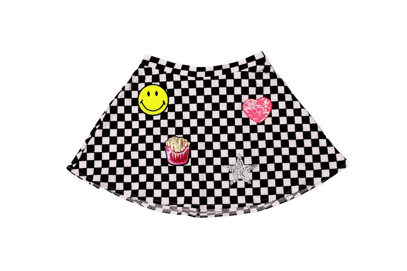 This skirt is black and white checkered with 4 patches on it: smiley face, pink sequin heart, sequin french fries and silver sequin star