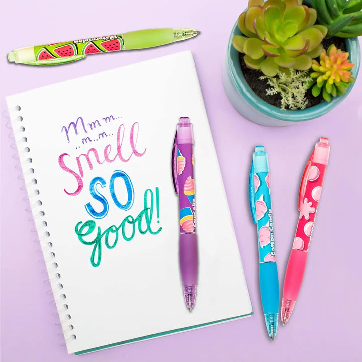 Colorful pens on a notebook with a plant on a purple background