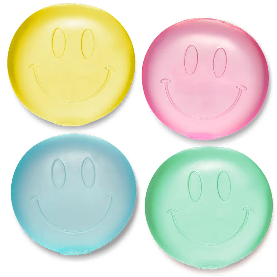 Four smiley face-squish toys in yellow, pink, blue, and green on a white background.