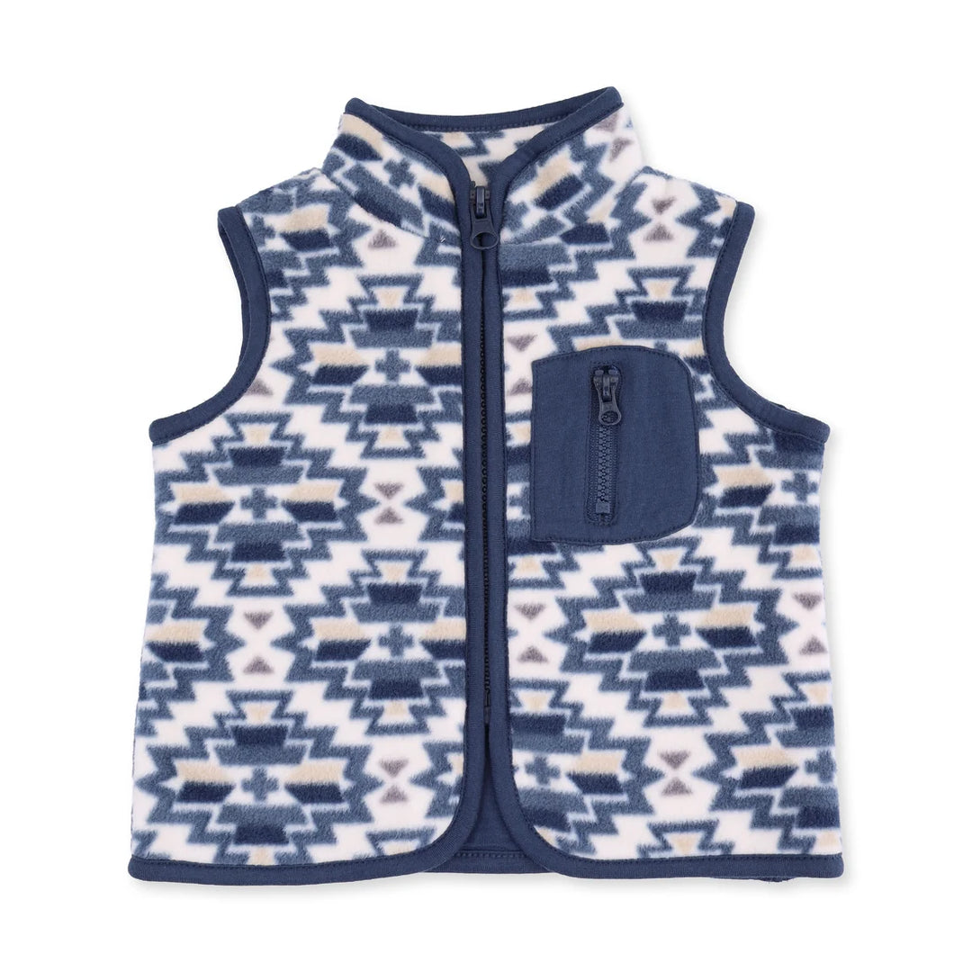 A sleeveless zip-front fleece vest with a geometric Southwestern pattern in navy blue, white, and light beige, featuring a solid navy blue chest pocket.
