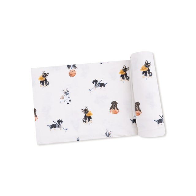 baby swaddle with puppies playing sports on it. 