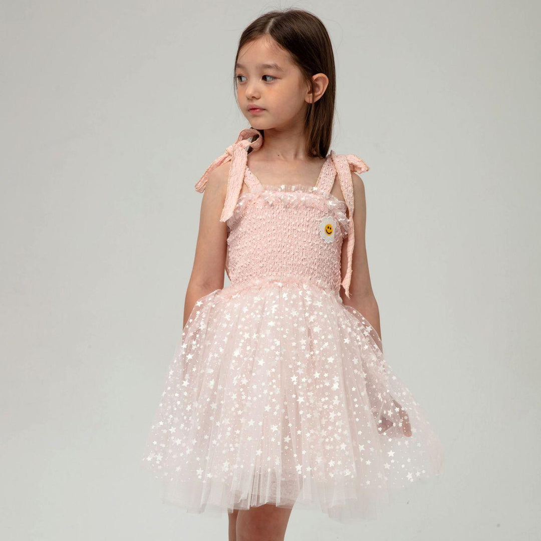 little girl modeling the pink and white tulle dress with tiny stars on it. 