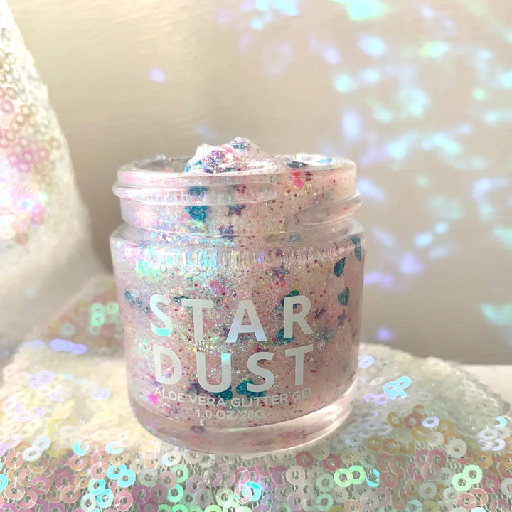 Jar of 'Star Dust' glitter gel on a sequin surface with a blurred background