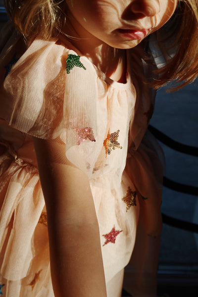 another close up of the dress on a little girl and where the top of the dress hits her arm. 