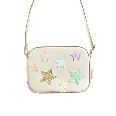 beige velvet handbag with pastel metallic stars attached in front. crossbody ability with this bag