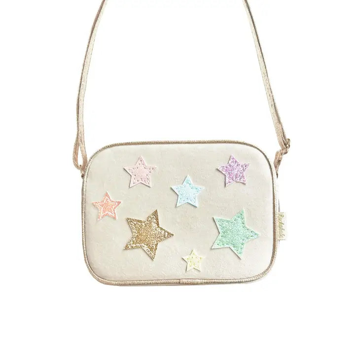 beige velvet handbag with pastel metallic stars attached in front. crossbody ability with this bag