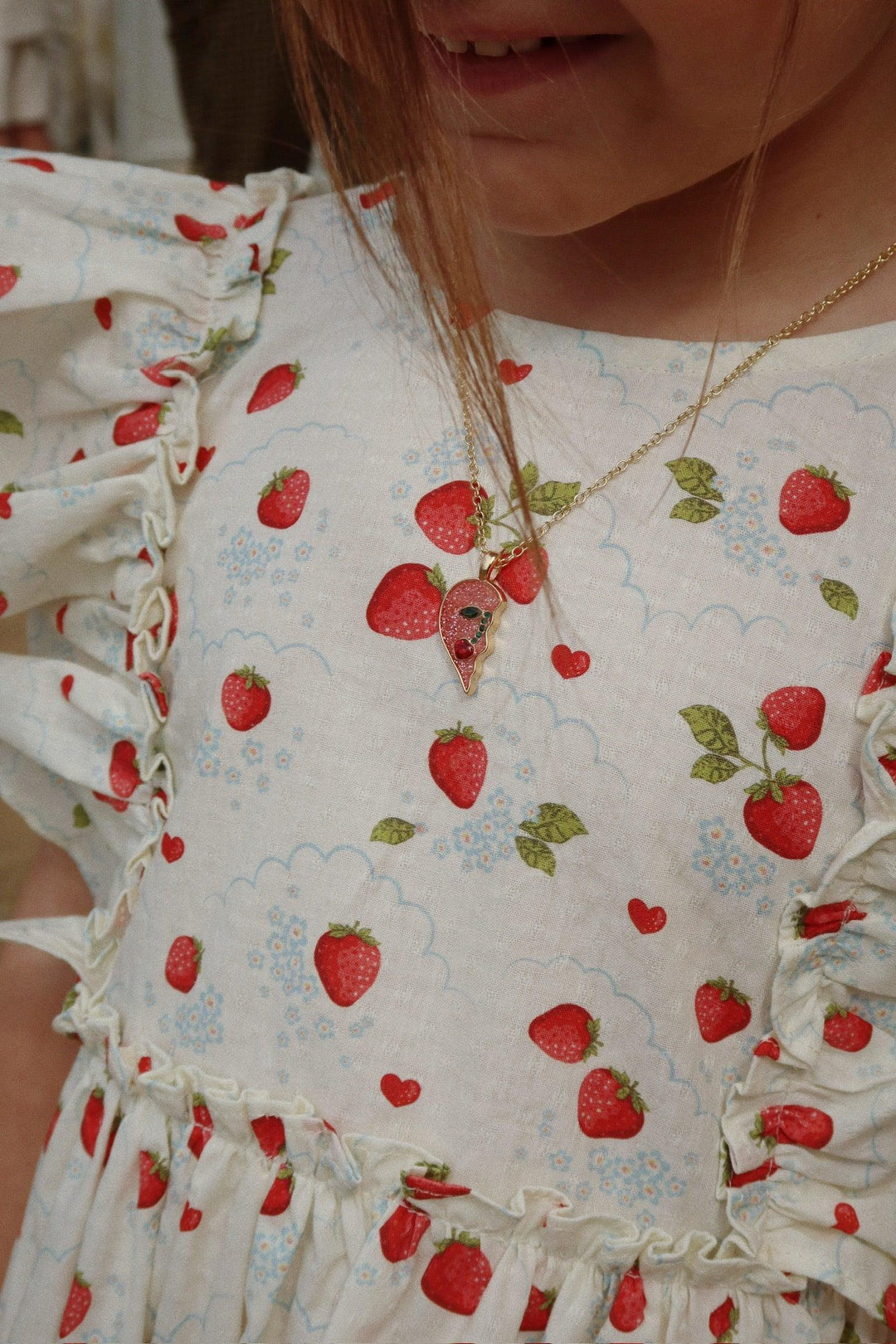 this picture shows the little girl modeling the dress with a close up of the pattern and how the sleevless ruffle appears on the girl. 