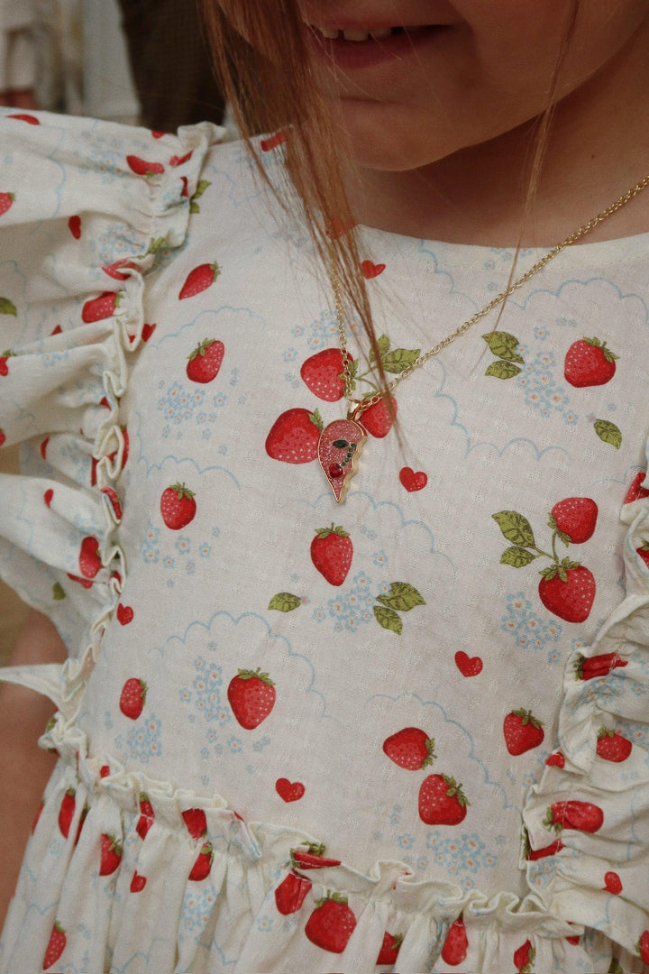 this picture shows the little girl modeling the dress with a close up of the pattern and how the sleevless ruffle appears on the girl. 