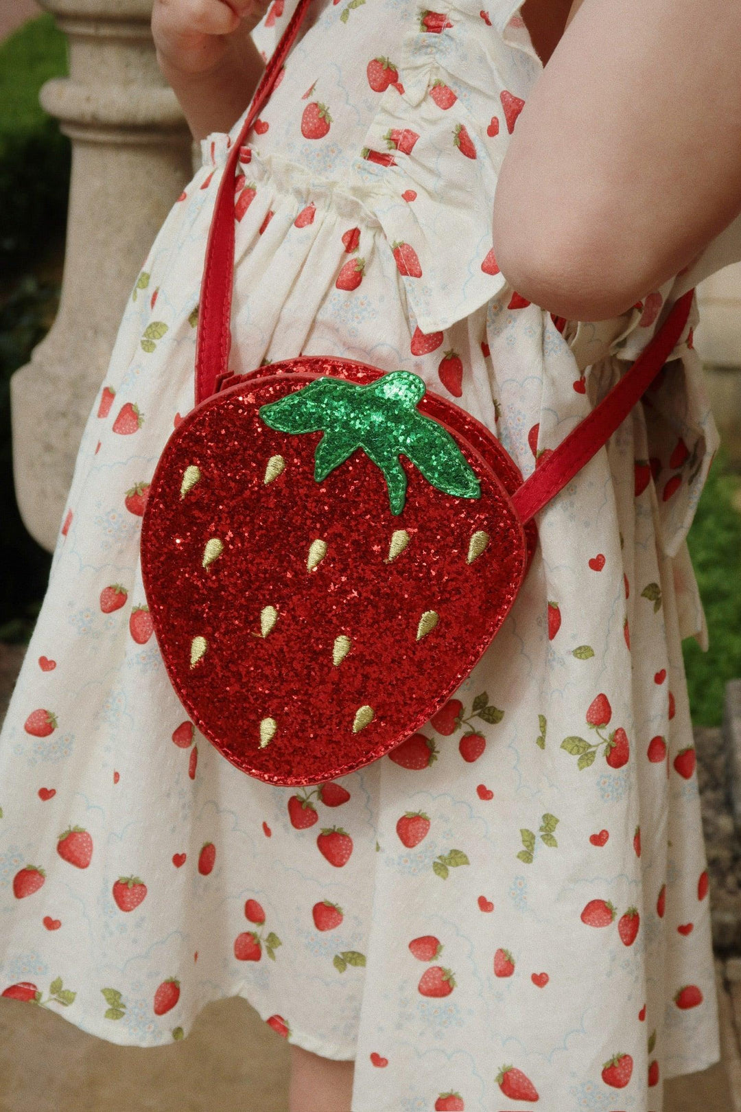 this picture shows the strawberry dress with a glittery strawberry bag 