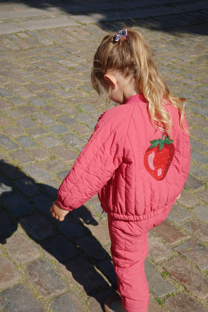 little girl modeling the pink bomber jacket with strawberry on the back. 