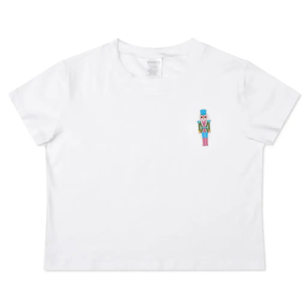 white tee with an embroidered nutcracker on the front 