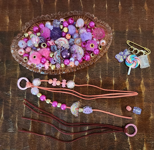 Colorful beads and strings on a wooden surface