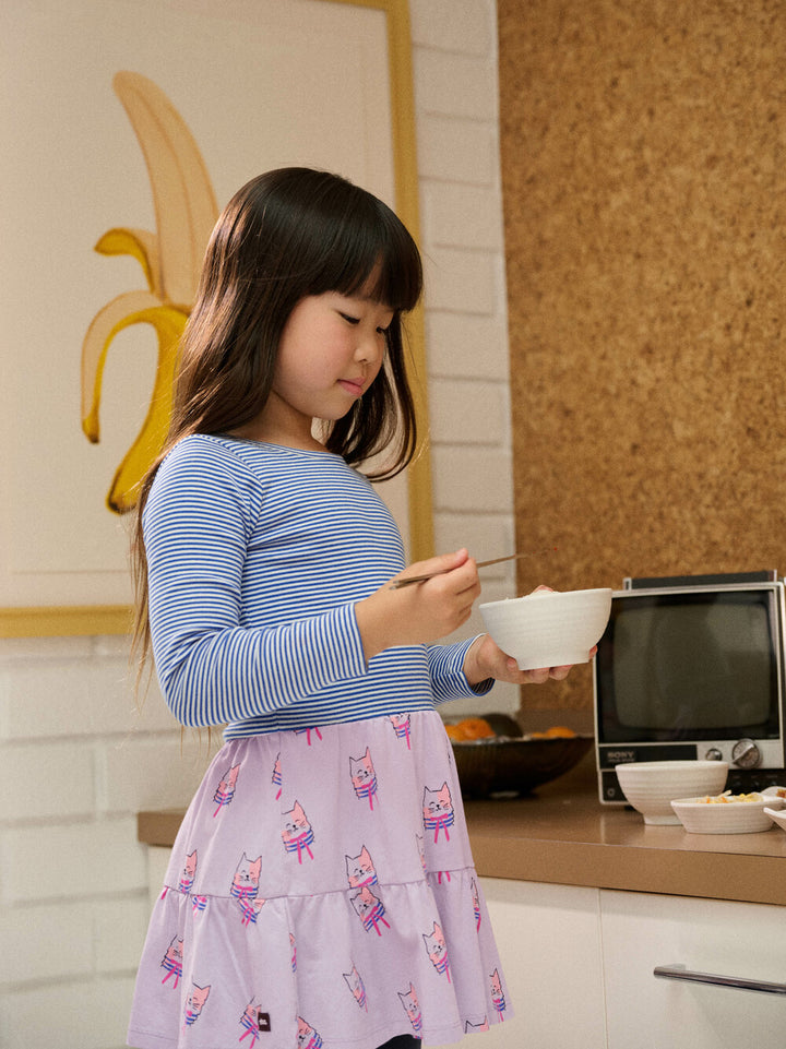 Young girl in a kitchen holding a bowl and spoon