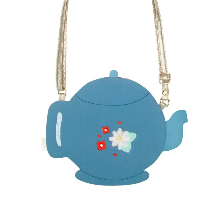 teapot shaped crossbody bag. Teapot has a tiny flower on it. gold crossbody strap that is adjustable