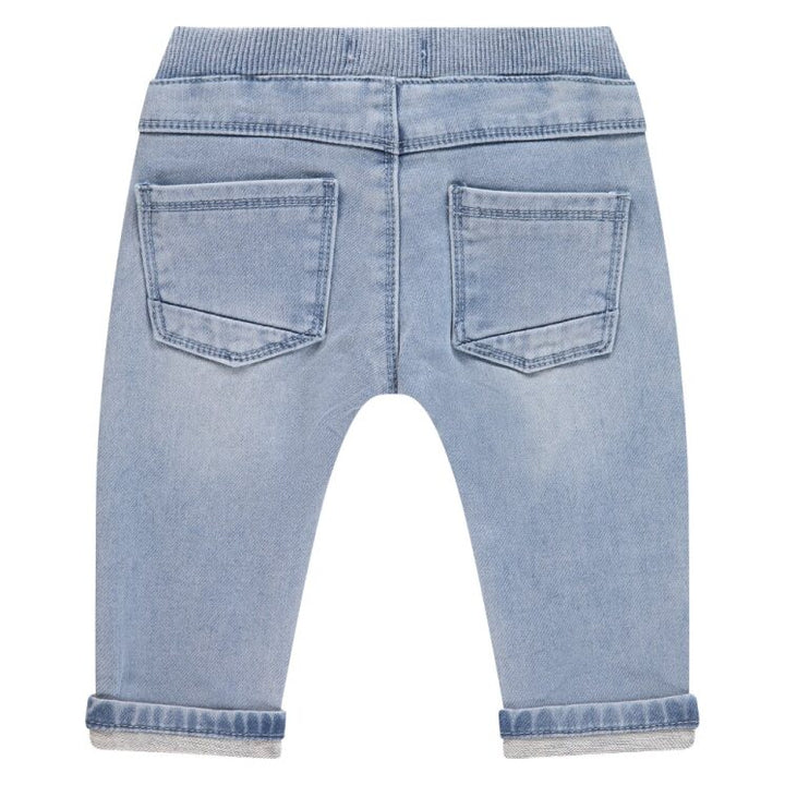 Back view of light blue denim jeans on a white background