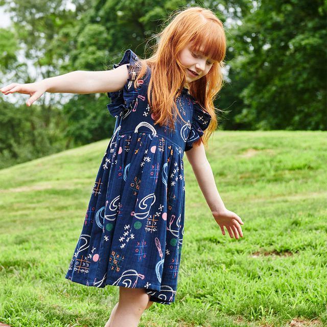 Child in a blue dress with  tice tac toe, jump rope theme dress.