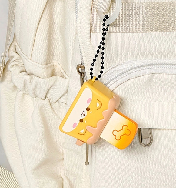 Yellow and pink cartoon-style toaster on a keychain with bread popping out the top that you need to click down. 