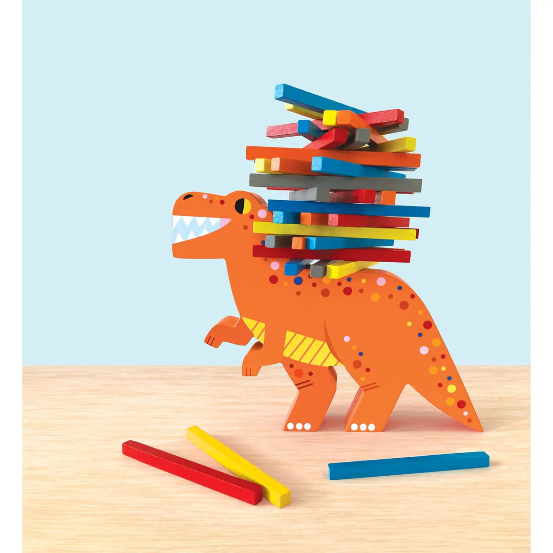 Colorful wooden blocks stacked on an orange dinosaur toy against a light blue background