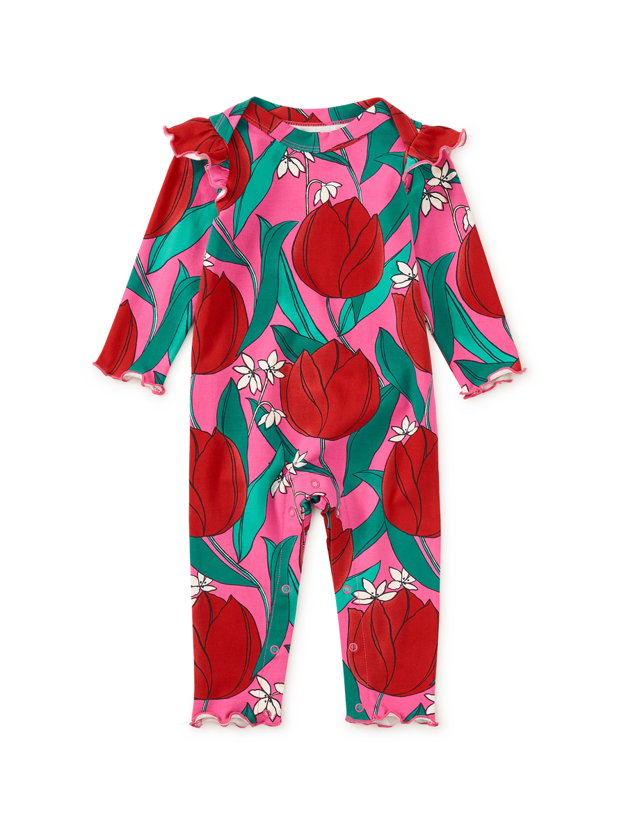 A baby long-sleeve romper with ruffled cuffs and collar, featuring a vibrant pink background with a red tulip and green leaf pattern, accented with small white flowers.