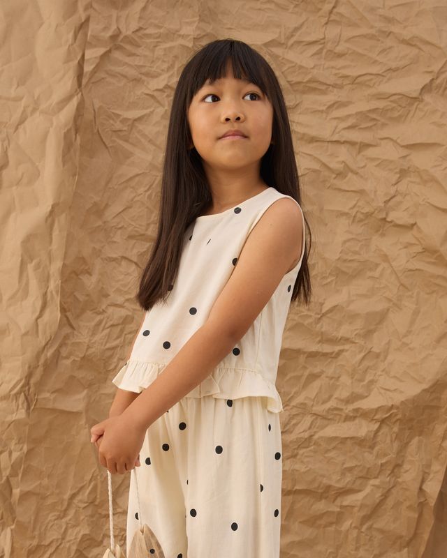 young girl wearing a polka dot top and wide leg pants 