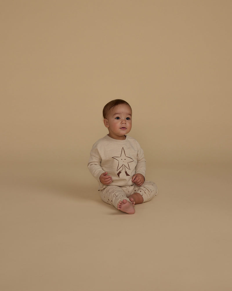 little baby modeling the twinkle set. tan star on the shirt and tiny little stars all over the pants. 