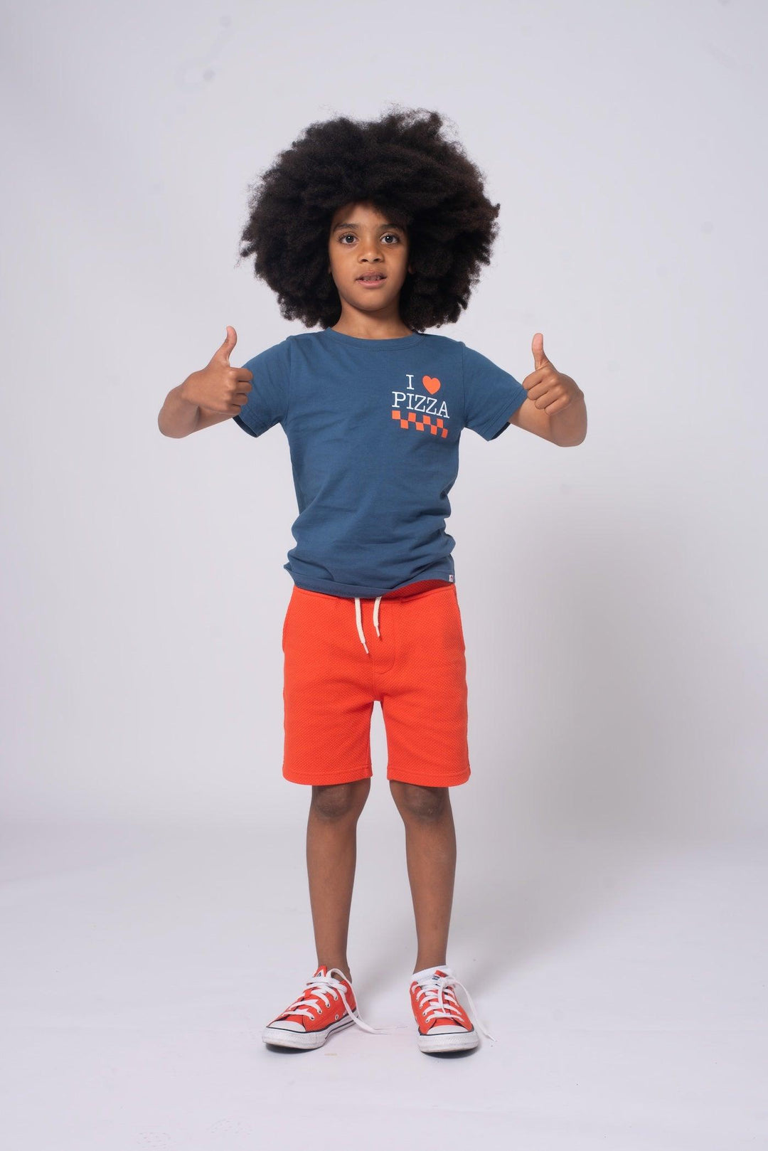Boy model wearing the Appaman graphic tree with orange camp shorts.