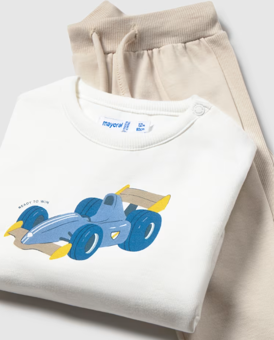 A folded white baby sweatshirt with a blue and yellow race car graphic, layered over a pair of beige ribbed pajama pants. The sweatshirt tag shows the brand 'mayoral'.