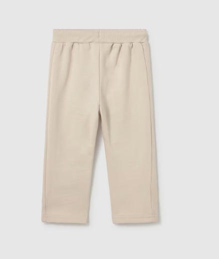 A pair of beige knit pants with an elastic waistband, shown flat against a light gray background.