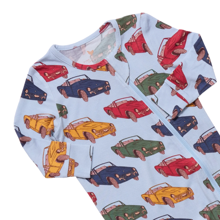 A baby long-sleeve zip-up sleeper in light blue, featuring an all-over print of retro convertible cars in red, yellow, green, and navy blue.