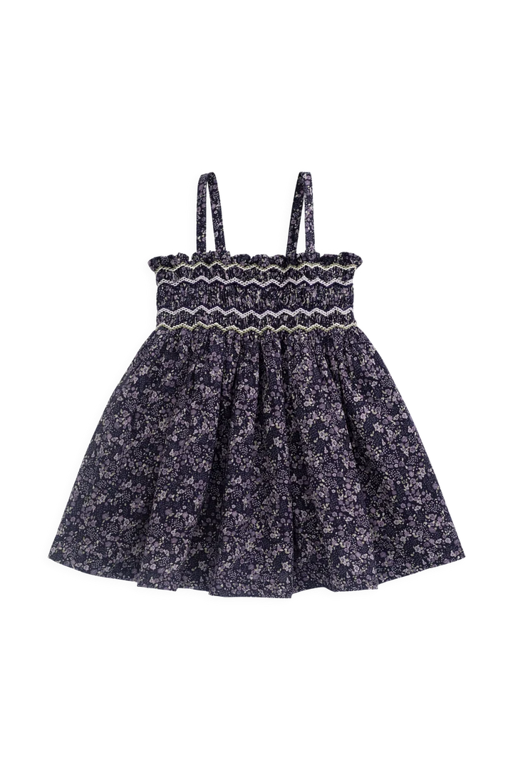 A toddler girl's sleeveless dress with a smocked bodice and a flared skirt, featuring a dark navy blue and white floral pattern.