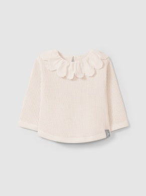 light pink waffle top for babies. small button in back on the top with delicate eyelet ruffle around the neck