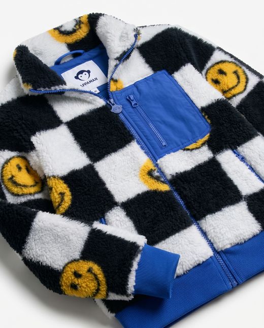 boys sherpa jacket with black and white check, blue accents and smiley faces all over. 