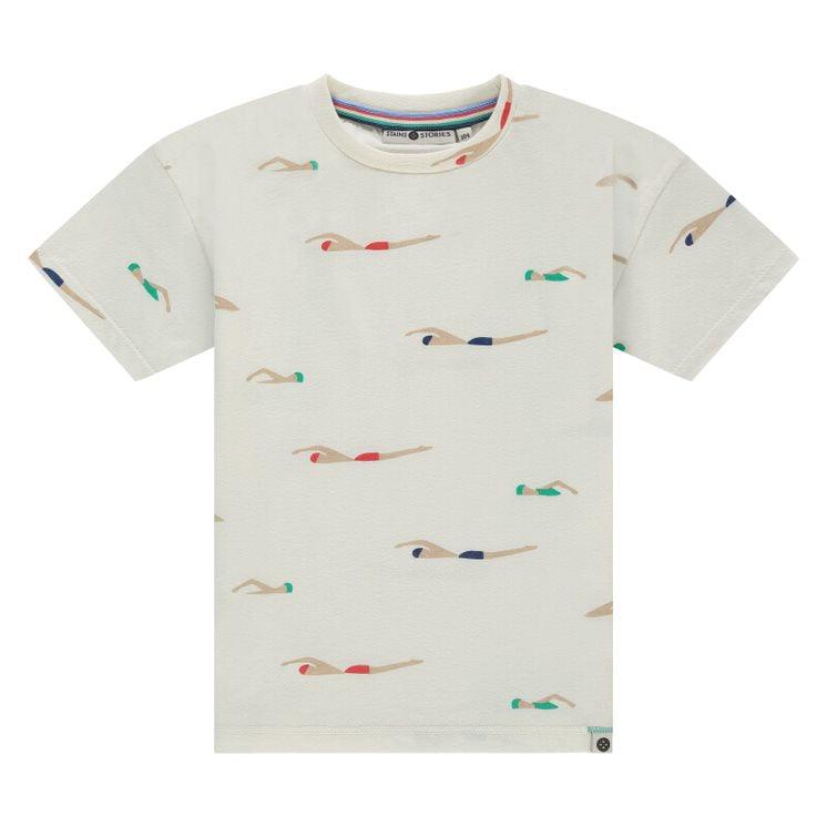 beige t-shirt with crew neck and short sleeves. graphic of swimmers swimming across the shirt with different color bathing suits on: red, green, blue. 