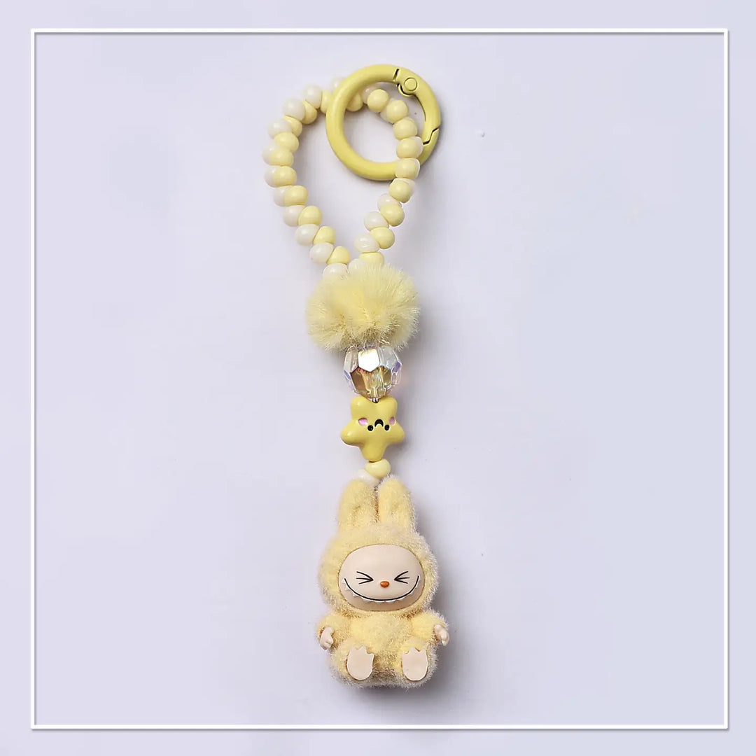 Yellow plush labubu toy on a beaded chain